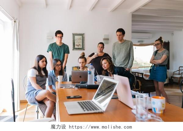 一群年轻人一起看着电脑讨论背景图片